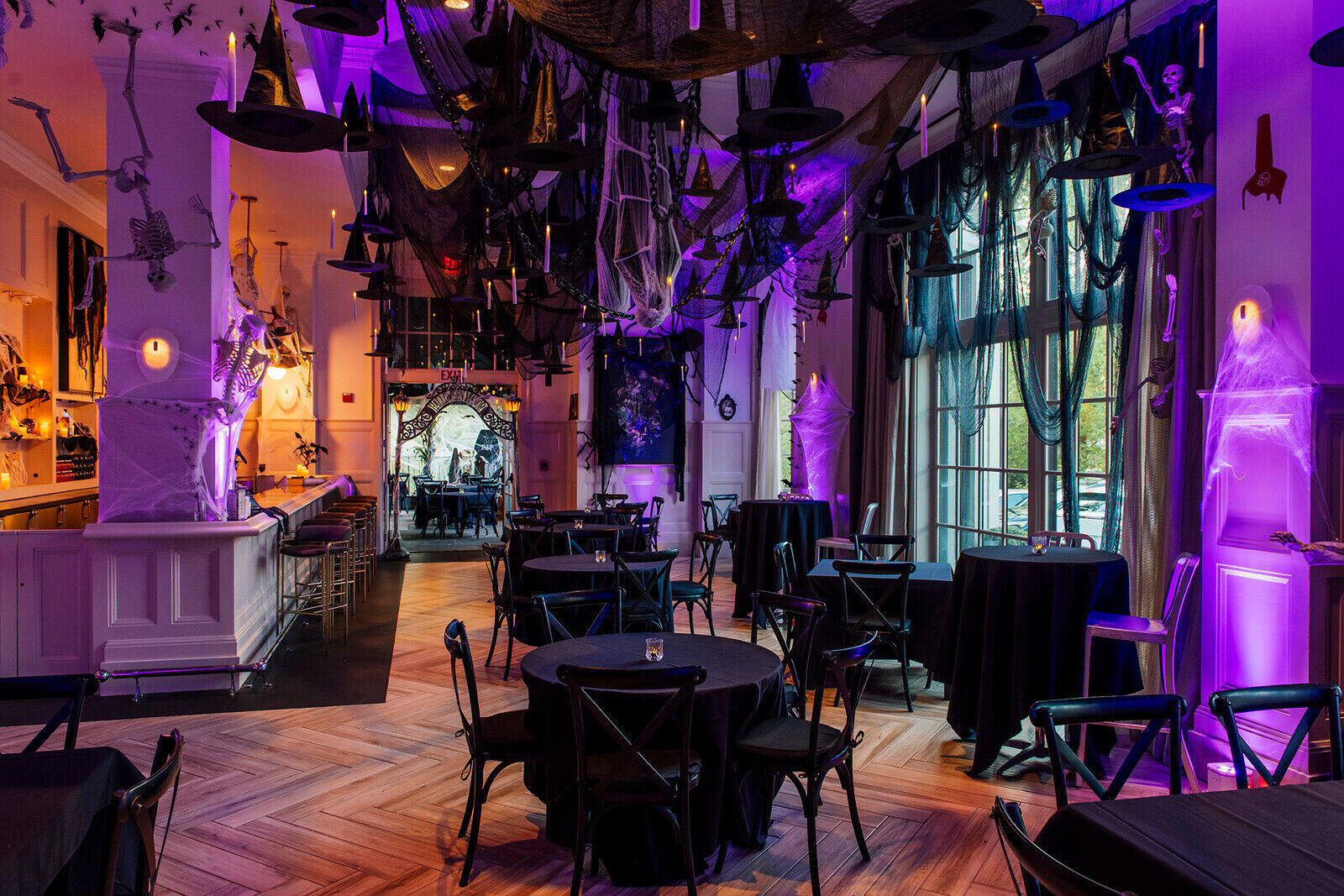 a room with tables and chairs and black and purple lights