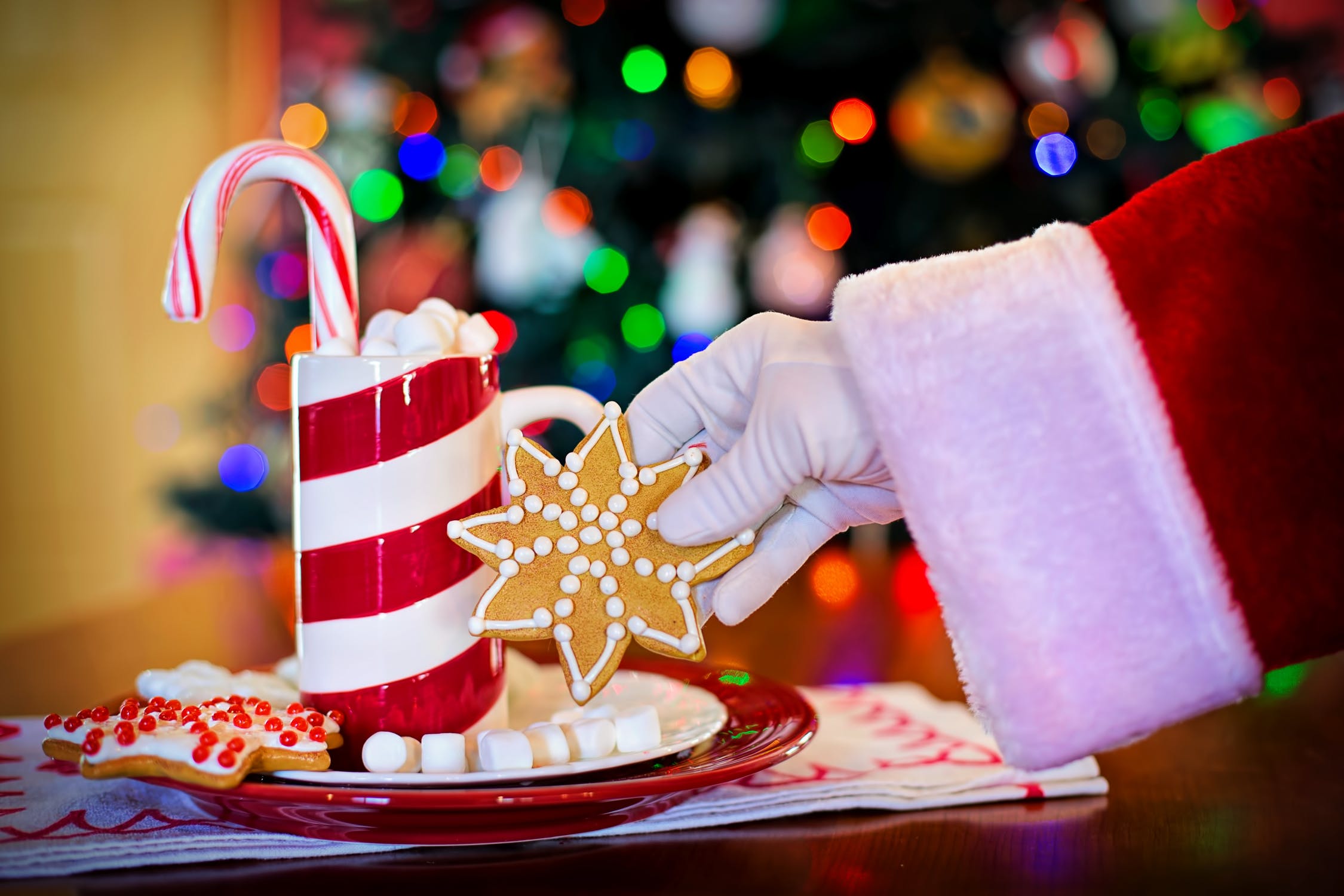 candy can cup with a santa holding a cookie in front of it